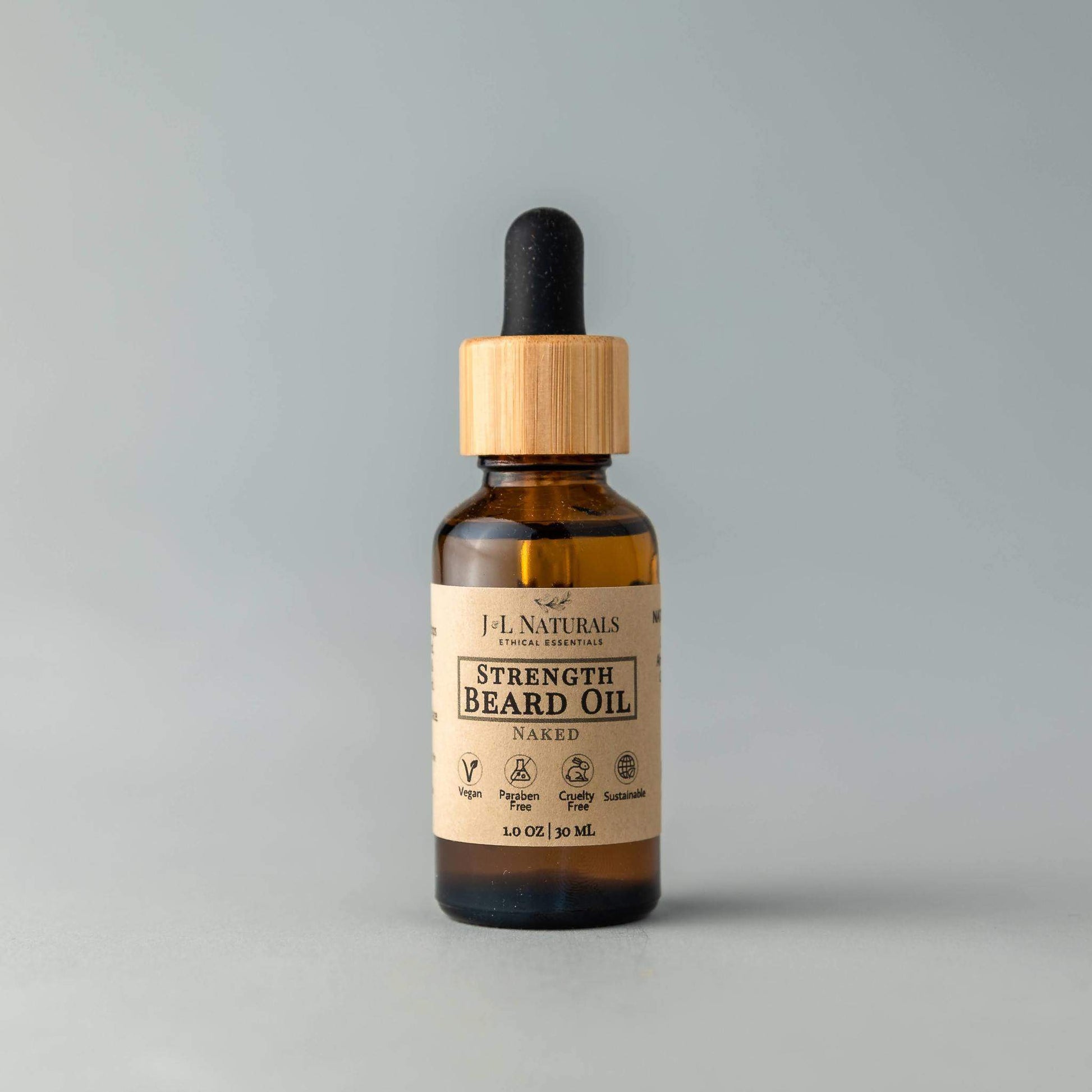 Bottle of strength beard oil with a wooden dropper on a gray background