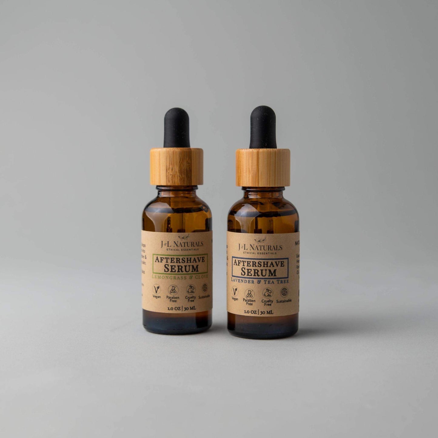 Two bottles of F.J. Naturals Aftershave Serum on a gray background
